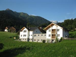 ein großes weißes Haus auf einem grünen Rasen in der Unterkunft Gästehaus Hausberger in Schruns-Tschagguns