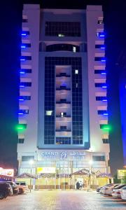 a large building with a parking lot in front of it at Grand PJ Hotel - Free Parking in Ras al Khaimah