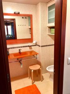ein Badezimmer mit einem Waschbecken, einem WC und einem Spiegel in der Unterkunft VIVIENDA CORRUBEDO VISTA DUNAS in Corrubedo