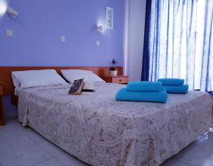 a bedroom with a bed with blue pillows on it at Pyrgos Hotel Apartments in Kremasti
