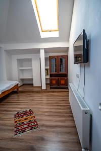 um quarto com uma cama e uma televisão na parede em Pensiunea VisAventura em Vişan