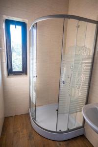a shower in a bathroom with a window and a sink at Pensiunea VisAventura in Vişan