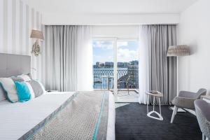 a hotel room with a bed and a balcony at Hotel Juliani - Boutique Hotel in St. Julianʼs