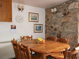a wooden table in a room with a stone wall at Valley Cottage in Penzance