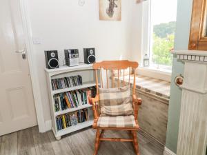 a wooden chair sitting in front of a book shelf at 2 Thompsons Buildings in Choppington