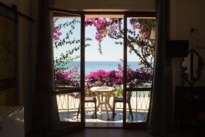 eine offene Tür mit einem Tisch und Meerblick in der Unterkunft Villa Sarina in Acciaroli