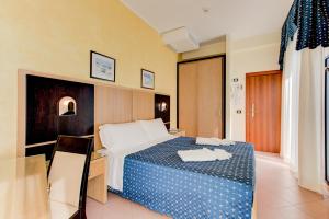 a hotel room with a bed with a blue and white at Hotel Verona in Cesenatico