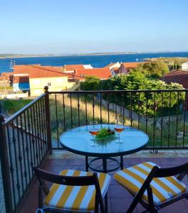 einen Tisch auf dem Balkon mit zwei Gläsern Wein in der Unterkunft VIVIENDA CORRUBEDO VISTA DUNAS in Corrubedo