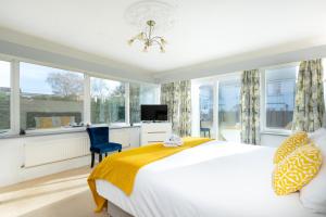 a bedroom with a bed and a tv and windows at KVM - Sugar Way House for large groups by KVM Serviced Accommodation in Peterborough