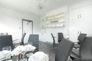 a dining room with a glass table and chairs at KVM - Sugar Way House for large groups by KVM Serviced Accommodation in Peterborough