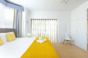 a bedroom with a bed with a yellow blanket at KVM - Sugar Way House for large groups by KVM Serviced Accommodation in Peterborough