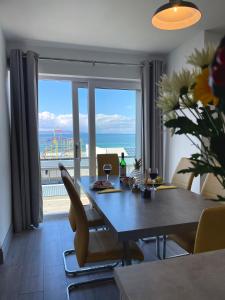 a dining room with a table and a view of the ocean at Portrush Penthouse in Portrush