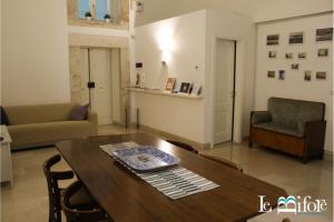 a living room with a wooden table and chairs at Le Bifore B&B in Molfetta