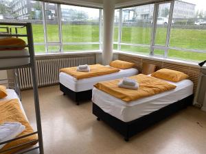two beds in a room with windows and a bunk bed at Hostel B47 in Reykjavík