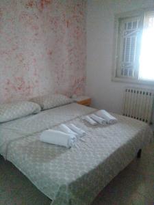 ein Schlafzimmer mit einem Bett mit Handtüchern darauf in der Unterkunft Villa Cesarea in Porto Cesareo