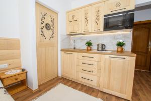 una cocina con armarios de madera y fregadero en Willa Halinka, en Zakopane