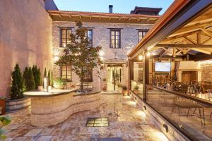 an outdoor patio with a table and chairs in a building at IALNA Boutique Hotel in Ioannina
