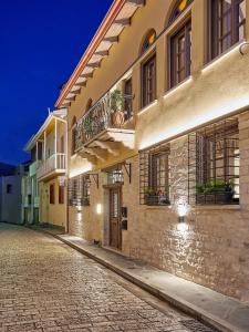 a building with a balcony on a cobblestone street at IALNA Boutique Hotel in Ioannina
