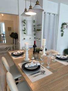 - une salle à manger avec une table en bois, des bougies et des verres à vin dans l'établissement Gare - Les Champs - 1 SDB privative - parking gratuit, à Saint-Brieuc