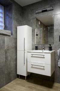 a white bathroom with a sink and a mirror at OSTOJA SŁAWIANOWO nad jeziorem in Sławianowo