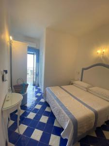 a bedroom with a bed and a blue and white tiled floor at Pensione Maria Luisa in Positano