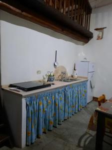 una cocina con una encimera con botellas azules. en Domo Sedda, en Galtellì
