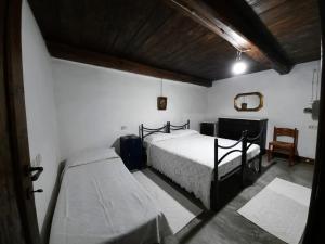1 dormitorio con 2 camas, mesa y silla en Domo Sedda, en Galtellì