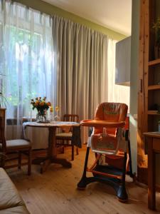 a living room with a table and a chair at Libau Baden apartamenti in Liepāja