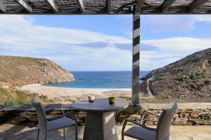 a table and chairs on a patio with a view of the ocean at Aegea Blue Cycladic Resort in Zorgos 