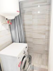 La salle de bains est pourvue d'un lave-linge et d'un sèche-linge blancs. dans l'établissement Студії біля Радіозаводу, à Ivano-Frankivsk