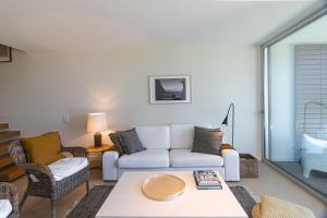 een woonkamer met een bank en een tafel bij Sagres Blue Villa H - 10 min walk to the beach in Sagres