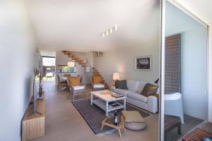 ein Wohnzimmer mit einem Sofa und einem Tisch in der Unterkunft Sagres Blue Villa H - 10 min walk to the beach in Sagres