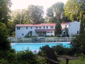 a swimming pool in front of a white house at Buttonwood Inn on Mount Surprise in North Conway