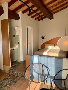 Cette chambre comprend un lit, une table et des chaises. dans l'établissement Il Poggio di Musignano, à Musignano