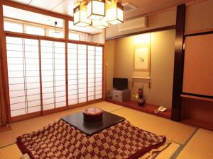 a living room with a table and a large window at Oyado Fubuki - Vacation STAY 45512v in Nozawa Onsen