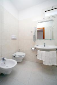 a white bathroom with a sink and a toilet at Bikini Hotel in Vieste