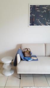 a woman is sitting on a white couch at Ferienwohnung Amselring in Heringsdorf