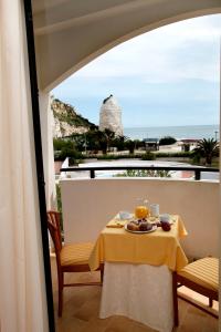 a table with a plate of food on a balcony at Bikini Hotel in Vieste