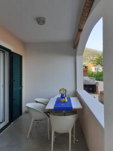 a dining room with a blue table and white chairs at Apartments Borovina in Bol