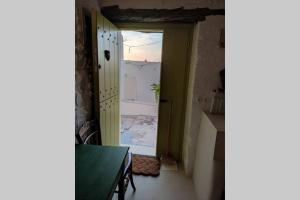 スキロスにあるΤο Παράσπιτοの緑のテーブルと景色を望むドアが備わる客室です。