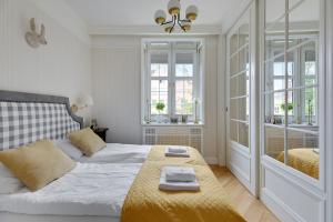 a white bedroom with a bed and a window at Dom & House - Old Town Swietego Ducha in Gdańsk