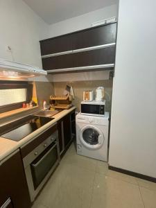 a kitchen with a washing machine and a washer at Apartamente Neptun Bosco in Neptun