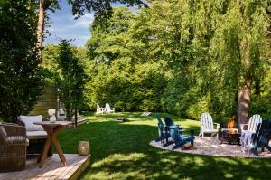 un patio trasero con sillas, mesa y chimenea en Journey East Hampton en East Hampton