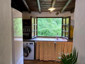 a kitchen with a washing machine and a window at Casa Rural Molino de Bony in Júzcar
