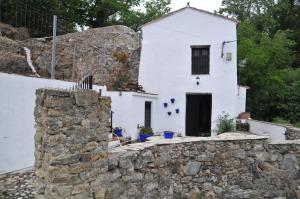 a white house with a stone wall at Casa Rural Molino de Bony in Júzcar