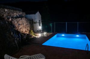 a swimming pool lit up at night at Casa Rural Molino de Bony in Júzcar