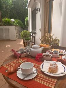stół z jedzeniem, kubkami i talerzami w obiekcie Casetta Eva w mieście Anacapri