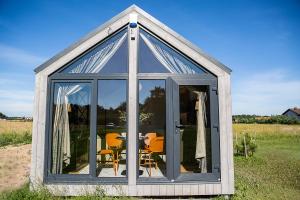 invernadero con mesa y sillas en un campo en Seaside wellbeing, en Dargužiai