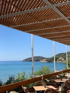 een uitzicht op de oceaan vanuit een restaurant met tafels en stoelen bij Golden Sand in Marathokampos