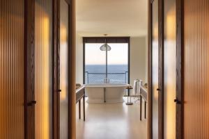 a bathroom with a tub with a view of the ocean at Six Senses Ibiza in Portinatx